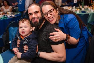An award winner takes a photo with her partner and child at the 2026 UFT Academic High School Awards. 