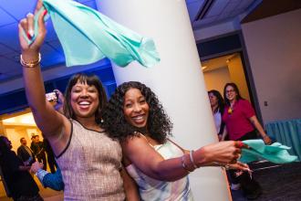 Two attendees at the UFT Academic High School Awards on May 15, 2026 wave their bandanas in celebration. 