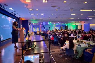 UFT Vice President for Academic High Schools Janella Hinds welcomes a crowd of some 300 people to the 2026 UFT Academic High School Awards. 
