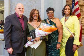 Giving Manhattan Borough Representative Servia Silva (second from left) her flowers as the recipient of the evening’s Trailblazer Award are (from left) Mulgrew and committee co-Chairs Walker Wilson and Lebby at the 2025 UFT African Heritage Committee Dinner Awards Dinner on Feb. 7, 2025. 
