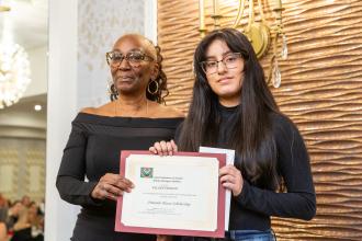 A student is presented with a scholarship at the  2025 UFT African Heritage Committee Awards Dinner on Feb. 7, 2025. 