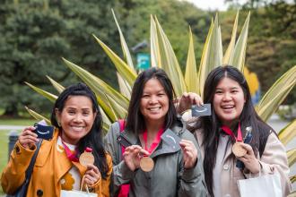 New UFT members show off their prizes won from the new member scavenger hunt held at the New York Botanical Garden on May 29, 2025. 