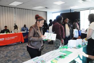 Yajaira Martinez, a parent of students at William H. Maxwell HS in Brooklyn’s East New York and MS 67 in Little Neck, Queens, browses the UFT’s Dial-A-Teacher table during the resource and vendor expo.