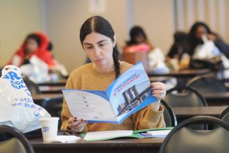 Jessica Juntz, a parent of a student at PS 889 in Flatbush, Brooklyn, browses her conference program.