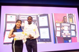 Speech teacher Rafi Mercie Feliciano of MS 581 in Brooklyn stands tall with student Makhi after winning recognition at the UFT Better Speech and Hearing Month celebration.