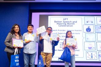 A speech teacher and her students at the UFT Speech Improvement Chapter's Better Speech and Hearing Month celebration show off their certificates they received for a project