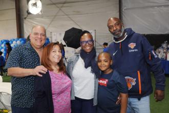 Teachers Lillian Rivera (second from left) and Ayisha Clayton of PS 100 in Queens enjoy the day with their families at UFT Family Day on March 29, 2025. 