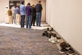 UFT Muslim Educators Committee members and guests gather to pray in a quiet space next to the room where dinner is being served at the UFT Muslim Educators Committee Iftar Dinner on March 7, 2025. 