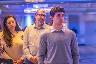 A student stands in front of his parents as he is announced as Student of the Year at the 2024 UFT Jewish Heritage Committee Tikkun Olam Awards Dinner on Dec. 5, 2024. 