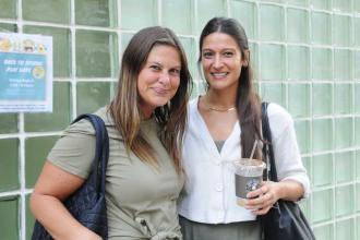 Two teachers stand outside a school