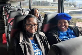 Two sisters who are also paraprofessionals smile for a photo on while on the UFT bus as it arrives in Albany for Lobby Day on March 10, 2025. 