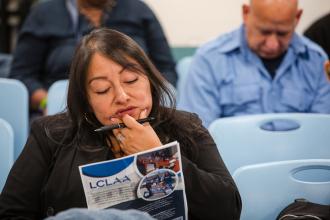 Emily Li, a volunteer Spanish interpreter, studies the program at the 2025 UFT Manhattan Parent Conference.