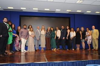 Honorees at the inaugural UFT Middle School Awards take a photo on stage. 
