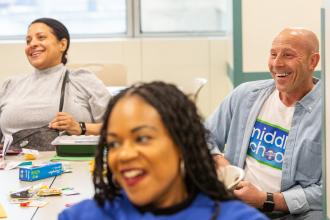 UFT Vice President for Middle Schools Richard Mantell shares a laugh alongside paraprofessional Sharlene Corcino (left) of JHS 194 in Queens and school counselor Roy of MS 581 during a workshop on boosting student morale.