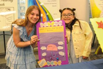 Sophie Lipstein of PS 34 in Brooklyn and her student show off their project, “Speech Showers Help Our Skills Bloom,” which helped the student with articulation goals.