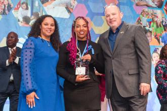 Kendra Edwards (center), a paraprofessional honoree from PS 23 in the Bronx, is congratulated by UFT Paraprofessionals Chapter Chair Priscilla Castro and UFT President Michael Mulgrew at the 2025 UFT Paraprofessionals Awards Luncheon on March 22, 2025. 