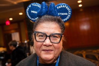 A paraprofessional in attendance at the UFT Paraprofessionals Awards Luncheon shows off her Mickey Mouse ears that she wears in class to amuse her students. 