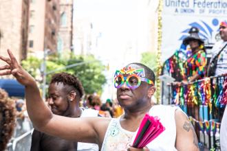UFT Pride Committee Chair Rashad Brown has fan in hand as he marches along the route in celebration at the 2025 NYC Pride March. 