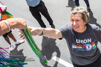 A UFT member gifts AFT President Randi Weingarten with some beads at the 2025 NYC Pride March.
