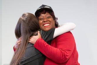 Mosalita McMillian, a member of the Queens parent committee that planned the conference, shares a hug with a mental health workshop participant.