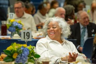 A retiree in attendance at the UFT Retired Teachers Chapter Luncheon laughs along with fellow retirees. 
