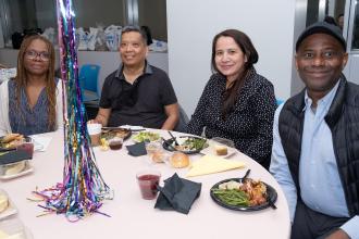 Four school nurses seated at a table take a photo during the UFT School Nurses Appreciation Dinner on May 7, 2025. 