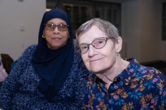 Two women sitting at a table smile for a photo during the UFT School Nurses Appreciation Dinner on May 7, 2025 at UFT headquarters. 