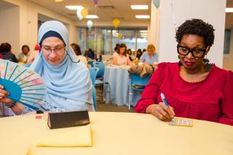 School nurses Mona Abdelgawad (left) of PS 68 on Staten Island and Alfreda Brown of Midwood HS in Brooklyn build ties while enjoying a game of bingo.