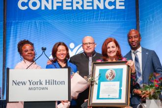 Standing with Win CEO Christine Quinn (4th from left) as she accepts the John Dewey Award, the union’s most prestigious honor for a nonunion member, are  (left to right) UFT Vice President Janella Hinds, UFT Treasurer Victoria Lee, Mulgrew and Schools Chancellor Kamar Samuels.