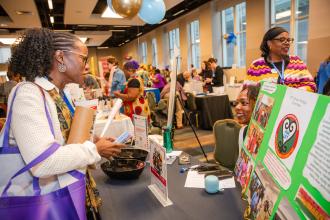 Joann Jones, a special education teacher at Pathways in Technology Early College HS in Brooklyn, takes in the African American Heritage Committee table in the Hall of the Americas, the exhibit hall at the 2026 UFT Spring Education Conference