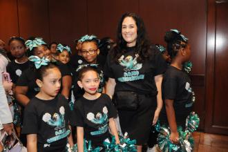 Teacher Danielle Istrico leads the cheer team from PS 160 in Queens as they prepare to perform at the opening of the exhibit.