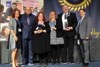 Receiving a Sidney Harris Award for outstanding leadership in special education are (starting third from left) Queens Mosaic Pre-K Center teacher Allison Ruina, Chapter Leader Theresa Schneider and principal Arthur Gnecco, flanked by UFT Vice President for Special Education Mary Jo Ginese (left), Mulgrew and Queens Borough Representative Tabio DaCruz (right).