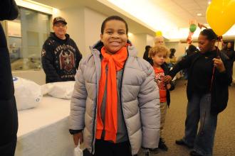 A student shows off a coat he received at the annual UFT Middle Schools Thanksgiving Luncheon