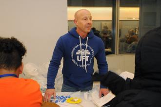 UFT Vice President for Middle Schools Richard Mantell, the architect of the coat drive and luncheon, hands out coats to students.