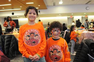 A pair of siblings, ages 8 and 5, show off their face paint and shirts before having lunch.