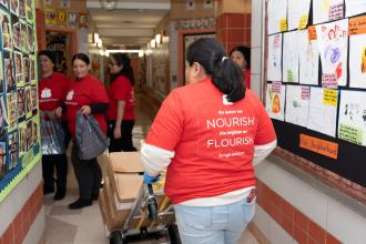 Parent volunteers at Manhattan’s PS 4 in Washington Heights prepare boxes and bags to be loaded with healthy produce.