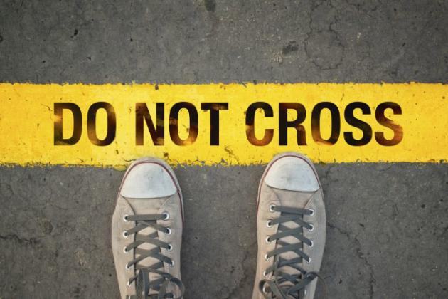 Sneakers touching a yellow do not cross line