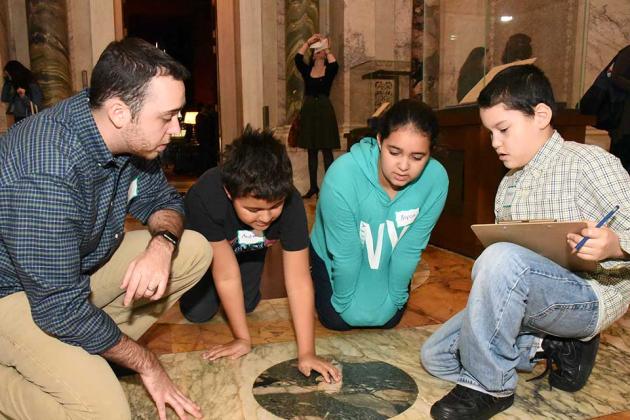 Students work alongside teacher Christopher Gianesses to study the pattern in th