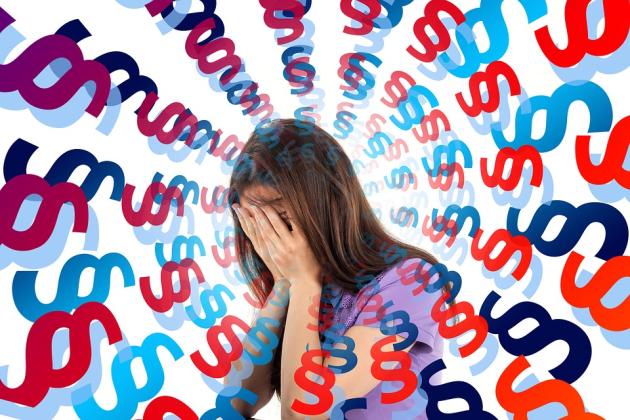 Women with hands covering face and a spiral of shapes indicating stress 