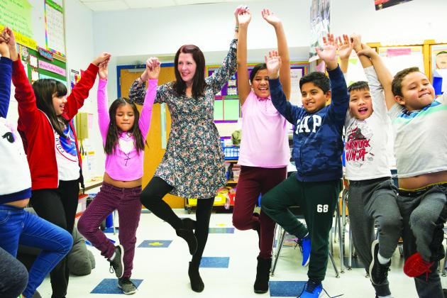 A group of students exercising with their teacher