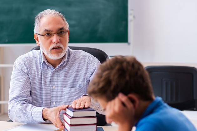 A teacher trying to get the attention of a student who will not make eye contact