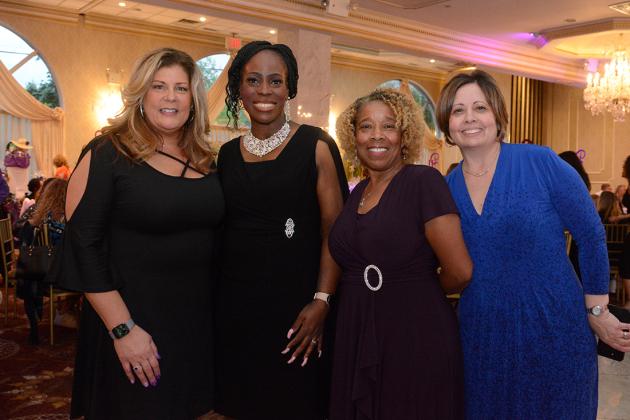 A group of four women pose for a photo