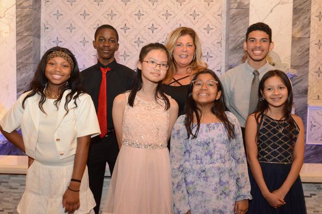 A group of students pose for a group photo with a UFT district representative 