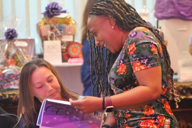 Two women look at the event program