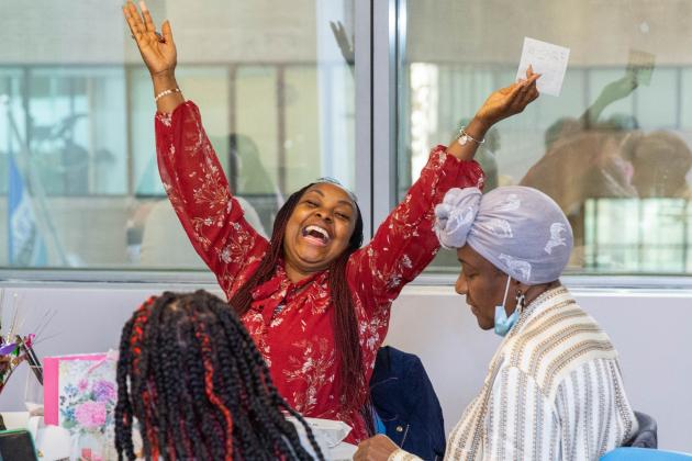 A woman holds her hands up high in celebration