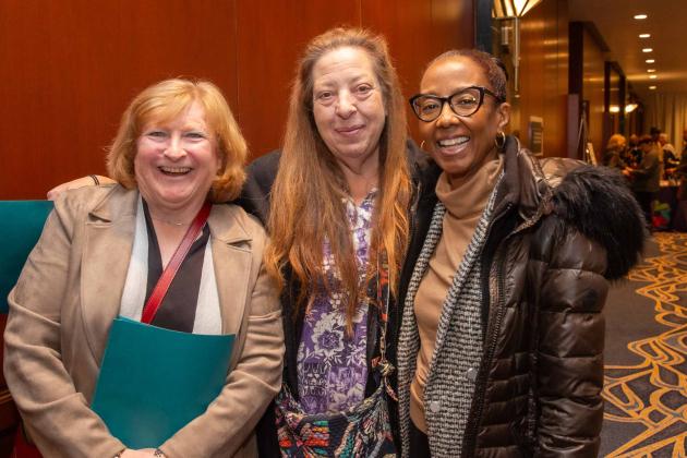 Three women pose for a photo outside of the ballroom
