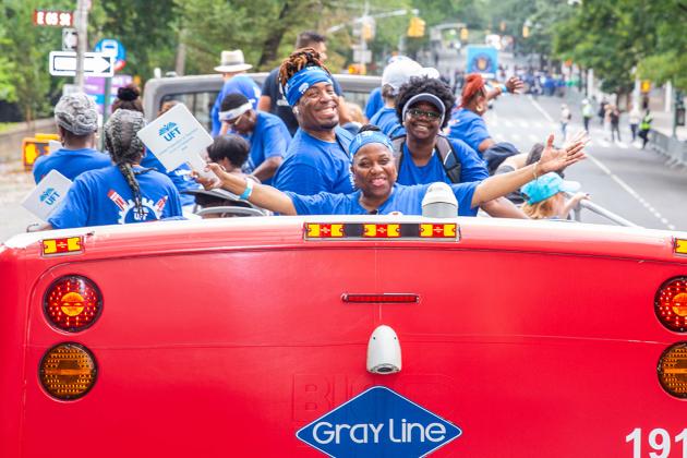 A group of members smile on the double decker bus 
