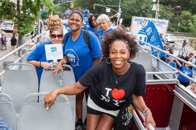 A group of attendees take a photo on top of a double decker bus