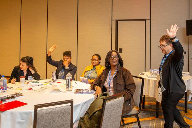 A woman on the right leads a workshop of participants
