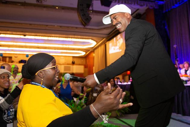 A man holds a microphone up to a women's face for her to sing along